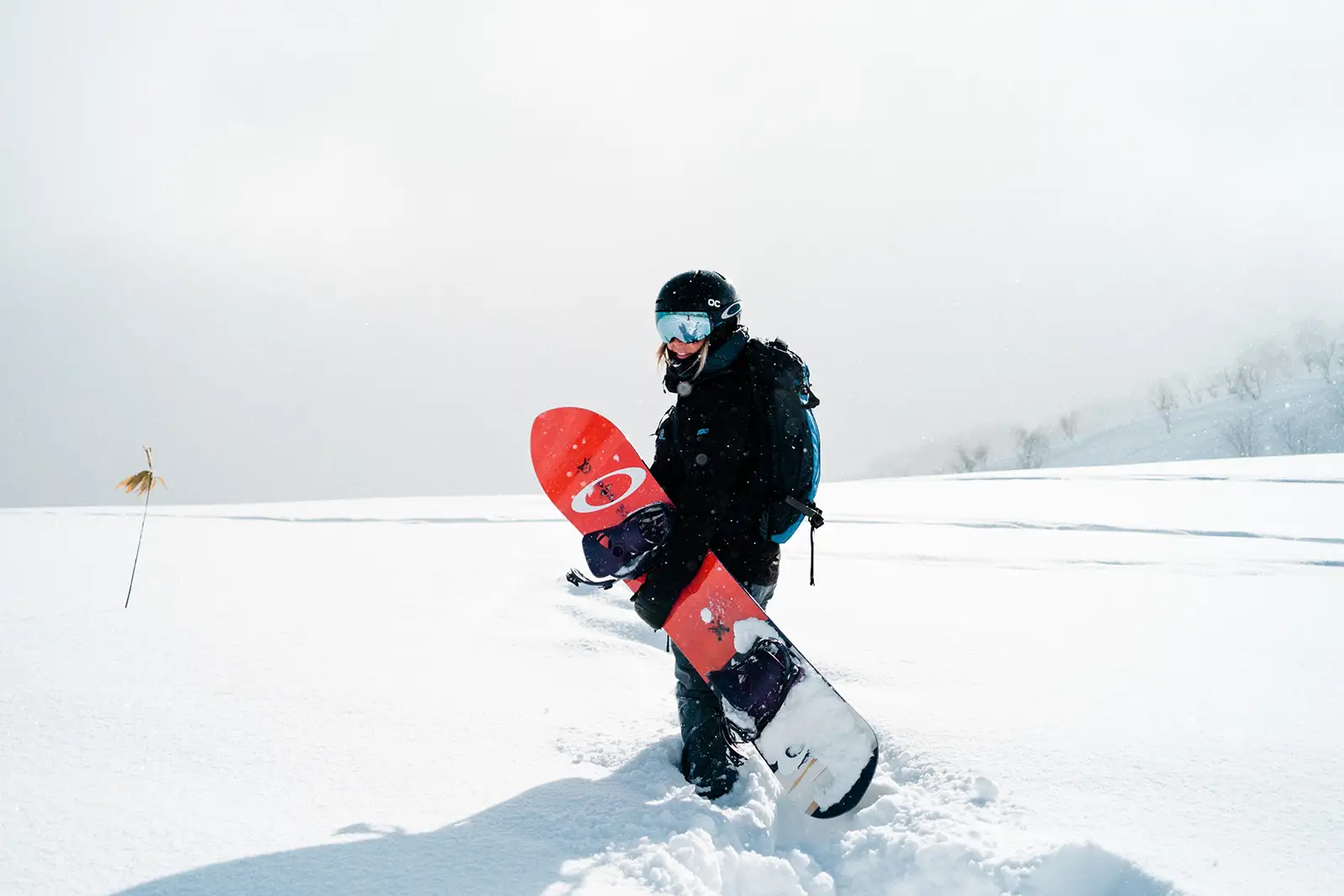 mujer con tabla de snowboard en la nieve